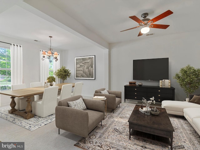 living room featuring a healthy amount of sunlight, ceiling fan with notable chandelier, and visible vents