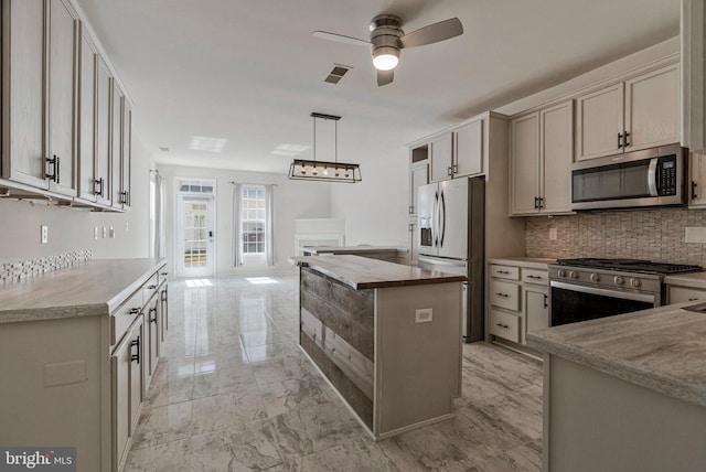 kitchen with decorative backsplash, a ceiling fan, visible vents, appliances with stainless steel finishes, and marble finish floor