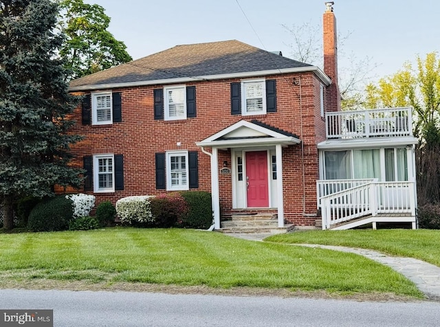 500 W Joppa Rd, Baltimore, MD 21204 - view of front of home featuring brick siding, a chimney, a balcony, and a front yard