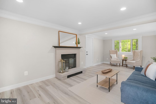 living area featuring a brick fireplace, ornamental molding, and wood finished floors