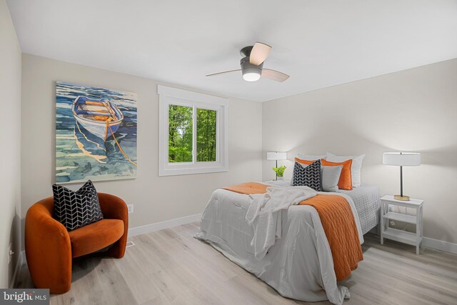 bedroom featuring baseboards, a ceiling fan, and light wood-style flooring