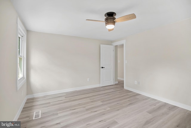 empty room with ceiling fan, visible vents, baseboards, and light wood-type flooring