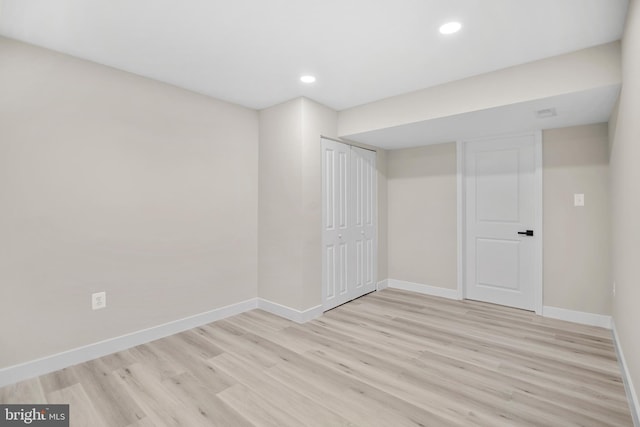 finished below grade area featuring light wood-style floors, baseboards, and recessed lighting