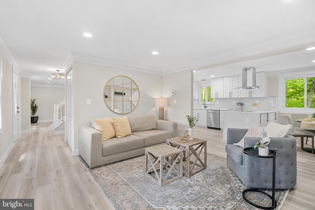 living room featuring light wood-type flooring, stairs, baseboards, ornamental molding, and recessed lighting