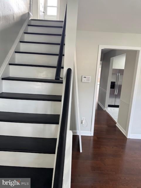 stairs featuring baseboards and wood finished floors