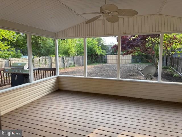 unfurnished sunroom with ceiling fan