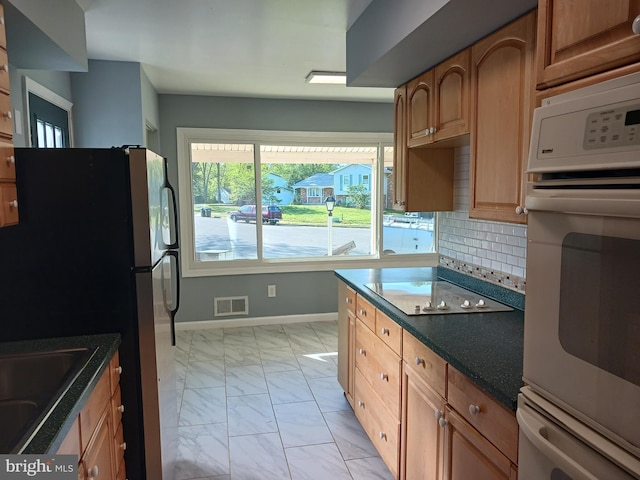 kitchen with a sink, white appliances, marble finish floor, baseboards, and visible vents