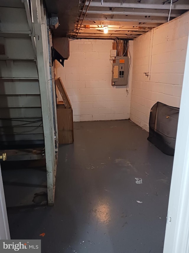 unfinished basement with electric panel and concrete block wall