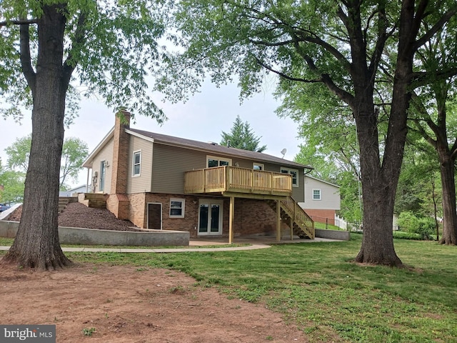 rear view of house with a wooden deck, a chimney, brick siding, stairs, and a yard