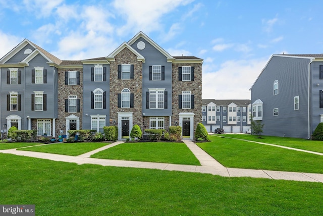 view of property with a front lawn and stone siding
