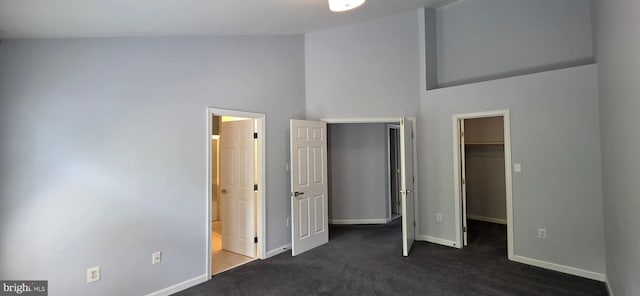 43183 Glenelder Ter, Ashburn, VA 20147 - unfurnished bedroom featuring a walk in closet, high vaulted ceiling, dark carpet, ensuite bathroom, and a closet