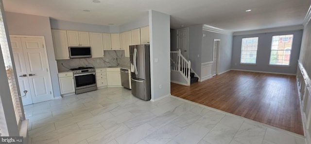 43183 Glenelder Ter, Ashburn, VA 20147 - kitchen featuring appliances with stainless steel finishes, light marble finish floors, open floor plan, backsplash, and light countertops