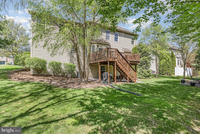 back of house featuring a yard, a deck, and stairs