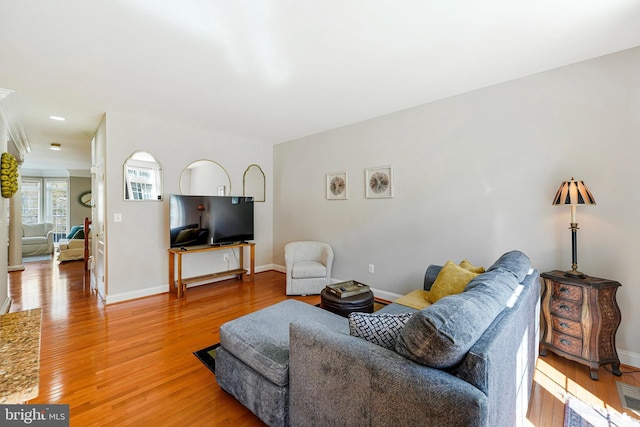 living area with baseboards and light wood finished floors