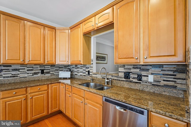 kitchen featuring stainless steel dishwasher, backsplash, and a sink