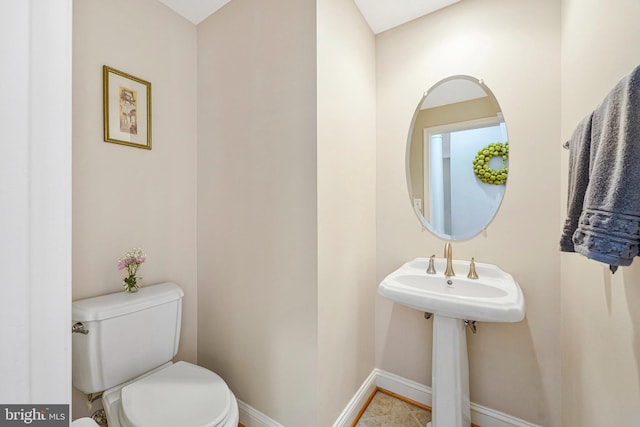 half bathroom with toilet and baseboards