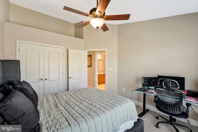 carpeted bedroom with a towering ceiling, a ceiling fan, baseboards, and a closet