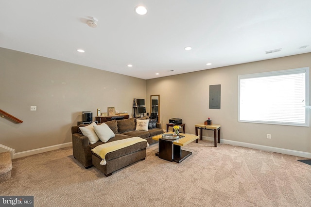 living area with carpet flooring, baseboards, visible vents, stairway, and electric panel