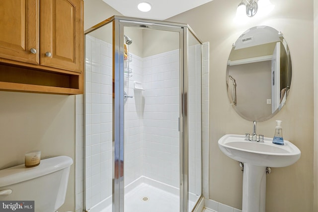bathroom featuring a stall shower and toilet