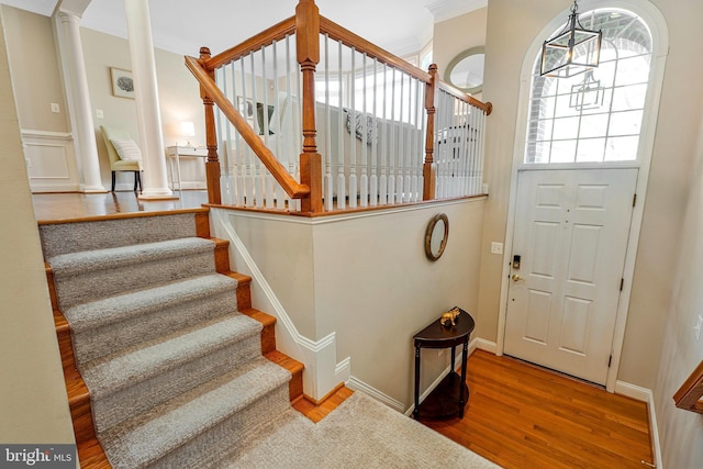 interior space with stairs, crown molding, and wood finished floors