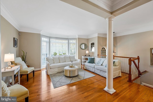 living area featuring wood-type flooring, baseboards, decorative columns, and ornamental molding