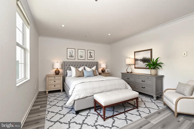 bedroom with crown molding, baseboards, wood finished floors, and multiple windows