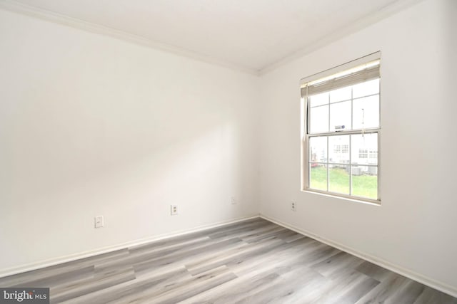 unfurnished room with crown molding, baseboards, and wood finished floors