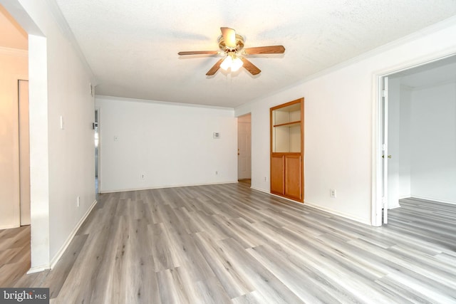 unfurnished living room with ceiling fan, a textured ceiling, crown molding, baseboards, and light wood-style flooring