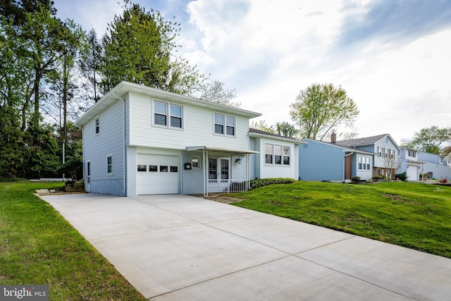 tri-level home with a garage, driveway, a front yard, and covered porch