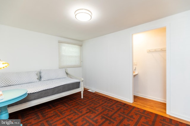 living area featuring baseboards, wood finished floors, and visible vents