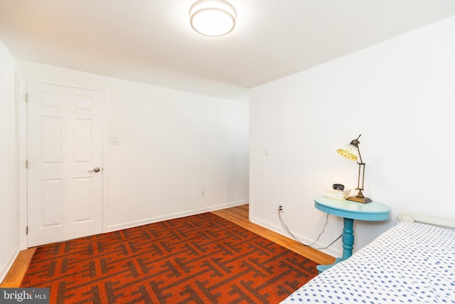 unfurnished bedroom with baseboards and wood finished floors