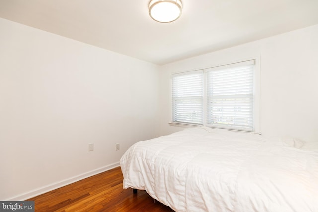 bedroom with baseboards and wood finished floors