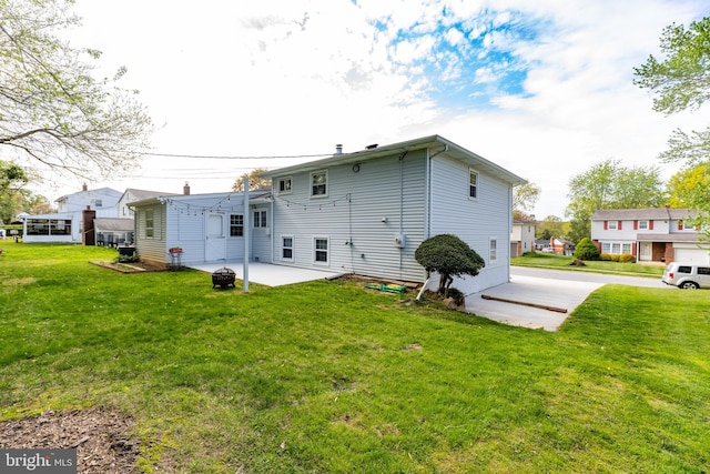 rear view of house with a lawn, a patio area, and an outdoor fire pit