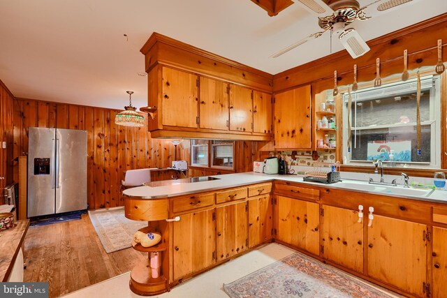 kitchen with ceiling fan, stainless steel refrigerator with ice dispenser, open shelves, a sink, and a peninsula