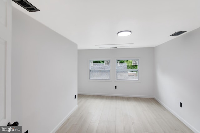 unfurnished room featuring visible vents, light wood-style floors, and baseboards