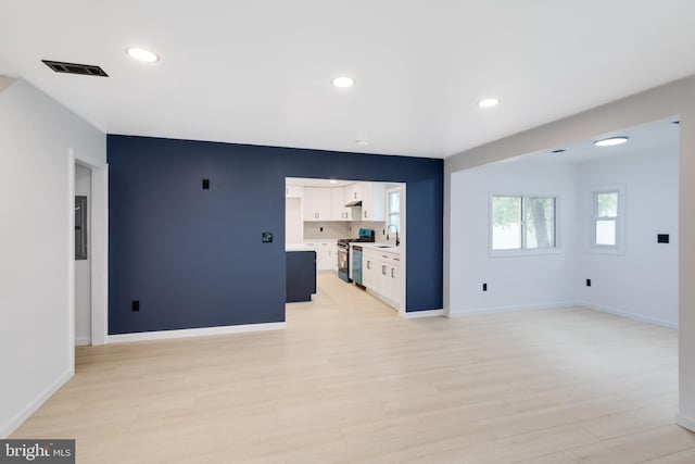 unfurnished living room with a sink, light wood-style floors, recessed lighting, and visible vents