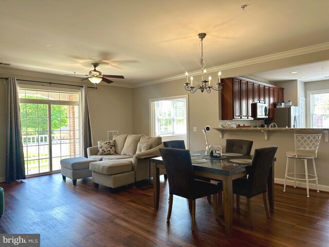 dining space with dark wood-style flooring, visible vents, baseboards, ceiling fan with notable chandelier, and ornamental molding