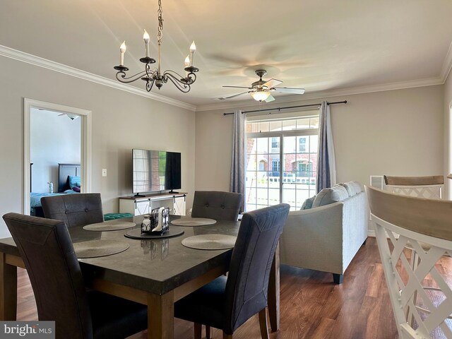 dining room with dark wood-style flooring, ornamental molding, and ceiling fan with notable chandelier