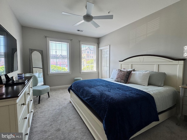bedroom featuring light colored carpet, baseboards, visible vents, and ceiling fan