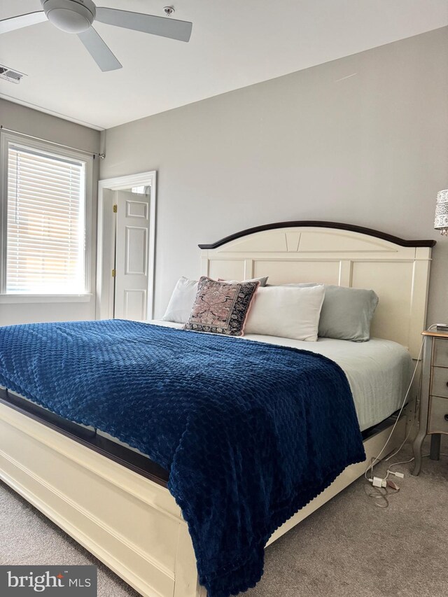 carpeted bedroom with visible vents and a ceiling fan