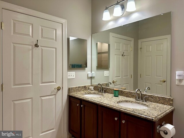 full bathroom with double vanity and a sink