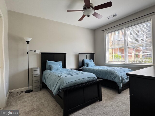 bedroom with visible vents, baseboards, ceiling fan, and light carpet