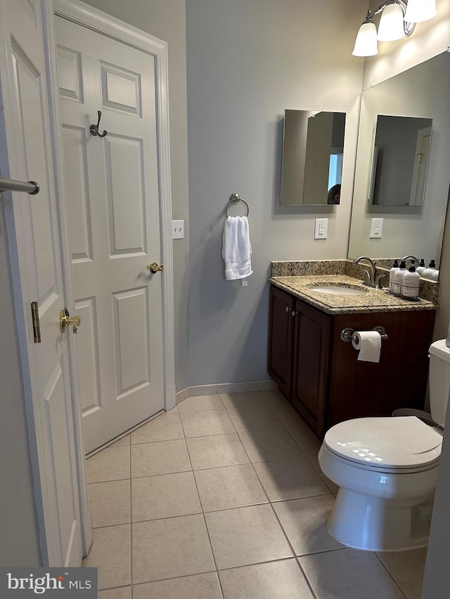 bathroom featuring toilet, baseboards, tile patterned flooring, and vanity