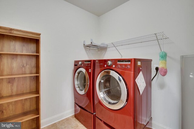 laundry room with separate washer and dryer, laundry area, baseboards, and tile patterned flooring