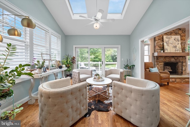 723 Ann Dr, Kennett Square, PA 19348 - living area featuring a skylight, a stone fireplace, wood finished floors, high vaulted ceiling, and ceiling fan