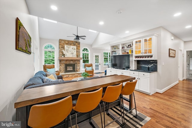 723 Ann Dr, Kennett Square, PA 19348 - kitchen featuring light wood-style flooring, a ceiling fan, white cabinetry, a stone fireplace, and baseboards