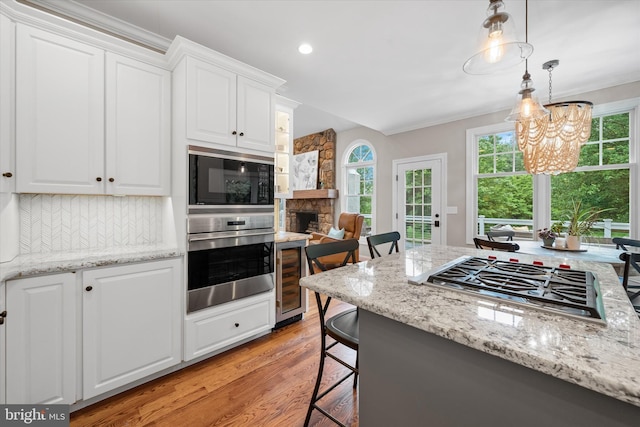 723 Ann Dr, Kennett Square, PA 19348 - kitchen featuring stainless steel appliances, wine cooler, light wood-type flooring, decorative backsplash, and white cabinets
