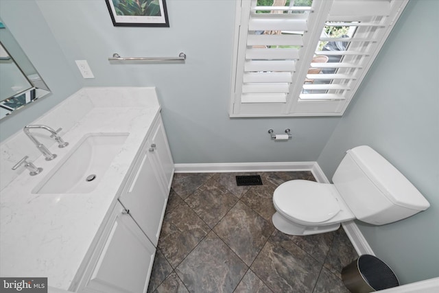 723 Ann Dr, Kennett Square, PA 19348 - half bathroom featuring vanity, baseboards, toilet, and stone finish floors