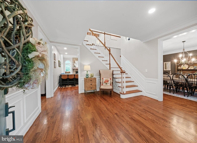 723 Ann Dr, Kennett Square, PA 19348 - entryway featuring stairs, wood finished floors, ornamental molding, wainscoting, and a chandelier