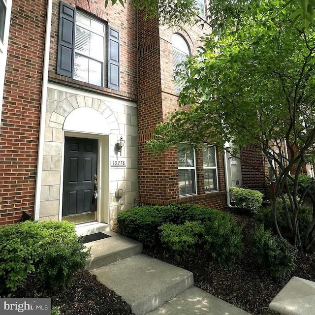 doorway to property featuring brick siding